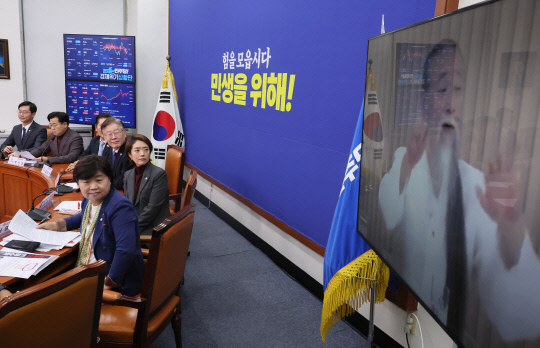 박찬대 더불어민주당 최고위원이 1일 국회에서 열린 최고위원회의에서  공개한 "경기도를 서울에 통합해야 한다"는 내용의 무속인 천공의 동영상을 이재명 대표 등 지도부가 보고 있다.<연합뉴스>